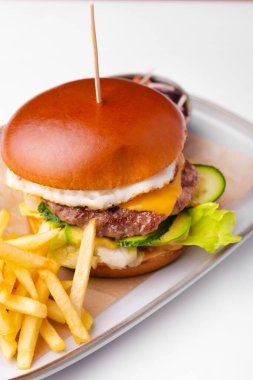 Menüde soslu sığır burger ve patates kızartması var.