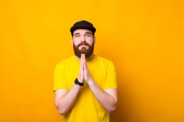 Lütfen, genç sakallı adamın bir şey için dua ederken fotoğrafı.