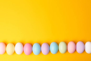 Süslü paskalya yumurtalarının sarı arka planda fotoğrafı.