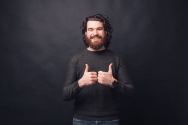 Siyah arka planda duran yakışıklı sakallı adamın fotoğrafı..