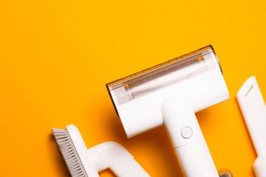 Sarı zemin üzerinde taşınabilir elektrik süpürgesinin üst görünümü.