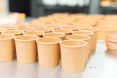 Beyaz bir masada boş kağıt bardak ve tabaklar.