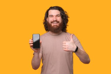 Bu iyi bir seçim, gülümseyen sakallı hippi parmağını gösterip akıllı telefon kullanıyor..