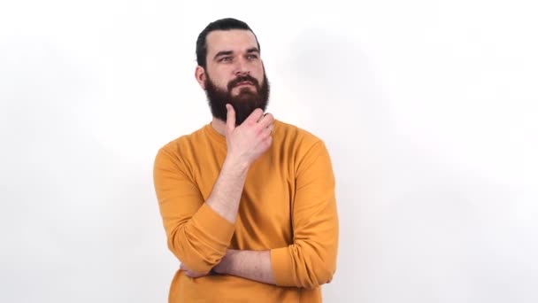 Beelden van een man met een baard die zijn baard denkt en aanraakt — Stockvideo
