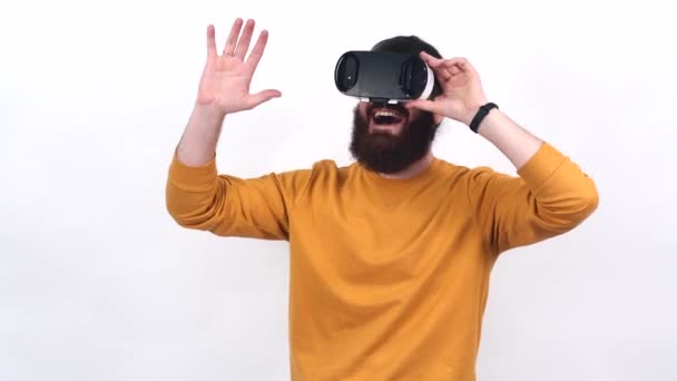 Видеозапись бородатого человека в желтом свитере, имеющего виртуальную реальность с VR очками. — стоковое видео
