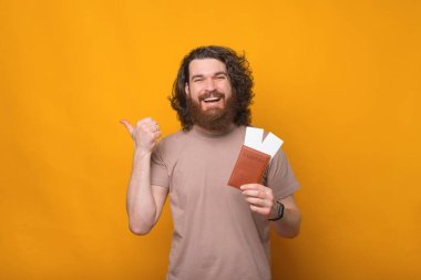 Sakallı, pasaportlu, biletli mutlu bir genç adam fotoğrafı..