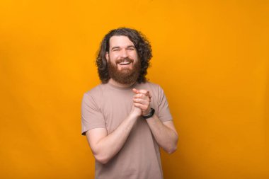 Kıvırcık saçlı, gülümseyen ve kameraya bakan neşeli sakallı adamın portresi..