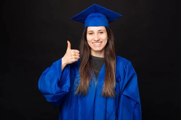 Cheerful student woman in bachelor graduating and showing thumb up.