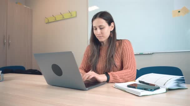 Felvétel fiatal nő ül az irodában, és használja laptop — Stock videók