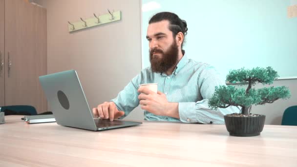 Filmación del hombre barbudo de la oficina bebiendo una taza de café — Vídeo de stock