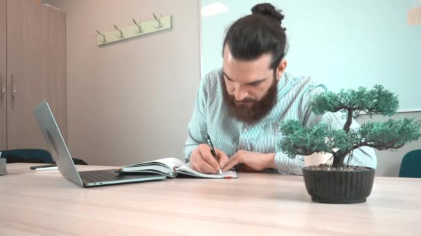 Images d'un employé de bureau prenant des notes dans son agenda quotidien — Video