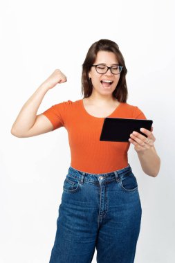 Tabletinde oynayan bir kız kazandığı için sevinçten bağırıyor. .