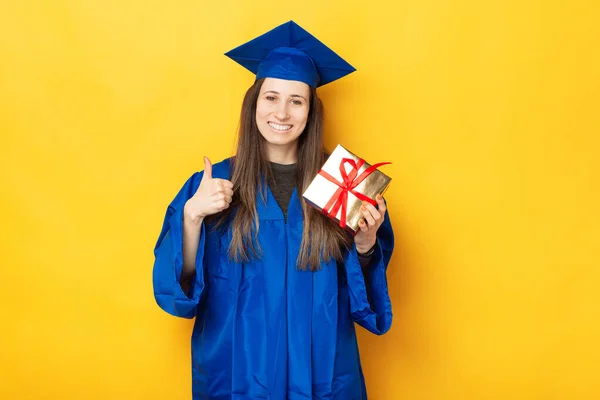 一个年轻的学生正对着摄像机笑 因为她收到了毕业礼物 — 图库照片