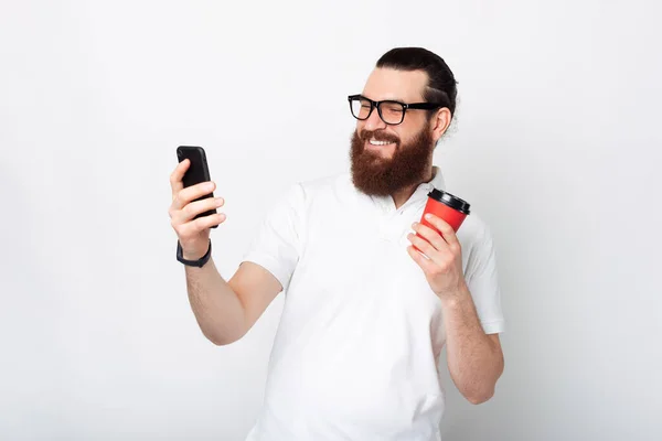 Cheerful Handsome Bearded Man Using Smartphone Holding Cup Coffee White — Stock Photo, Image