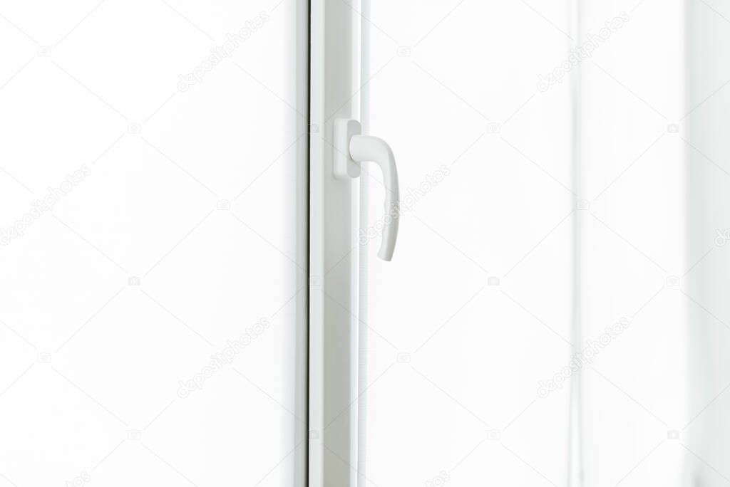 Close up photo of a white window handle on daytime