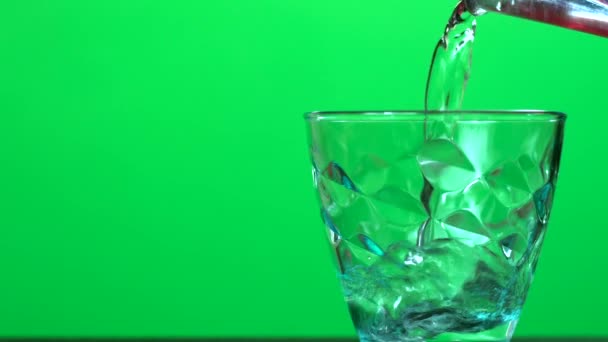 Close up footage of pouring water in glass over green screen — Stock Video