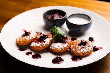 Peynirli krep, reçel ve krema ile ahşap bir masanın üzerinde güzel dekore edilmiş tabaklar..