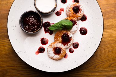 Üstünde reçel ve ekşi krema olan peynirli krep resmi..