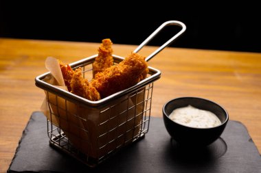 Küçük bir sepetteki ahşap bir masada kızartılmış nugget.