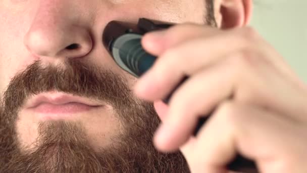 Fechar imagens de homem usando barbeador em sua barba — Vídeo de Stock