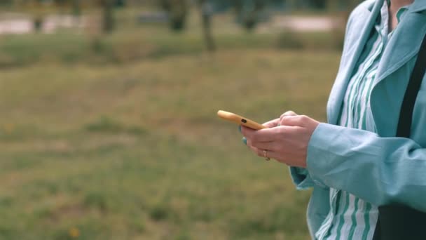 Nahaufnahme einer Frau beim beiläufigen Tippen auf dem Smartphone im Freien — Stockvideo