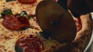 Şefin taze, taze ve lezzetli İtalyan pizzasını kestiği görüntüleri kapatın.