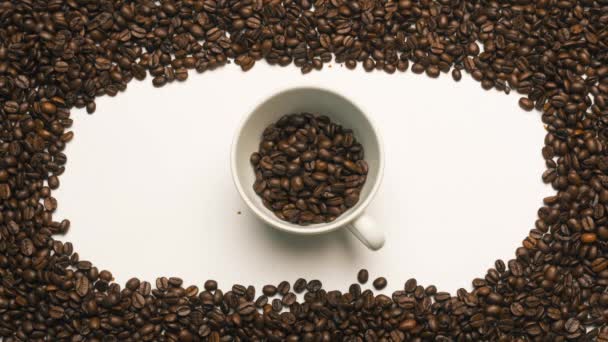 Stop movimento di tazza di caffè in ceramica e chicchi di caffè rotante — Video Stock