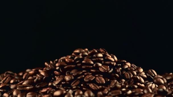 Закрыть кадры на тёмном фоне с вращающимися кофейными зёрнами — стоковое видео