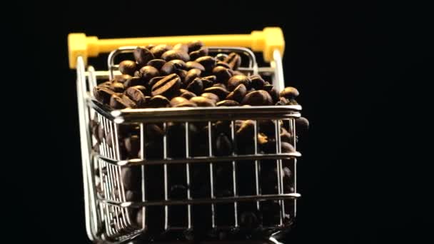어두운 배경 위에 커피콩 이 가득 한 회전하는 쇼핑 트롤리의 모습 — 비디오
