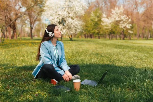 Zdjęcie Młodej Niezależnej Kobiety Siedzącej Miejskiej Trawie Parku Słuchającej Muzyki — Zdjęcie stockowe