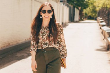 Gün ışığında yürüyen gülümseyen genç bir girişimcinin güzel bir resmi. .