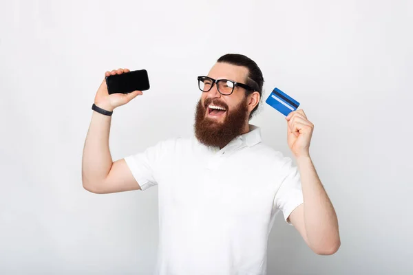 Retrato Hombre Barbudo Excitado Sosteniendo Teléfono Inteligente Tarjeta Crédito Azul — Foto de Stock