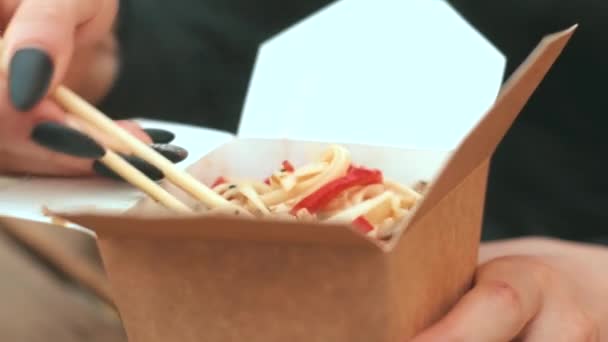 Close up footage of woman eating Chinese noodles outdoors, street food — Stock Video