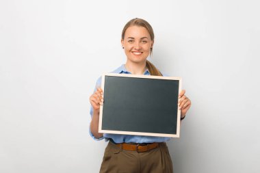 Stüdyoda beyaz arka planda genç ve şık bir kadın var..