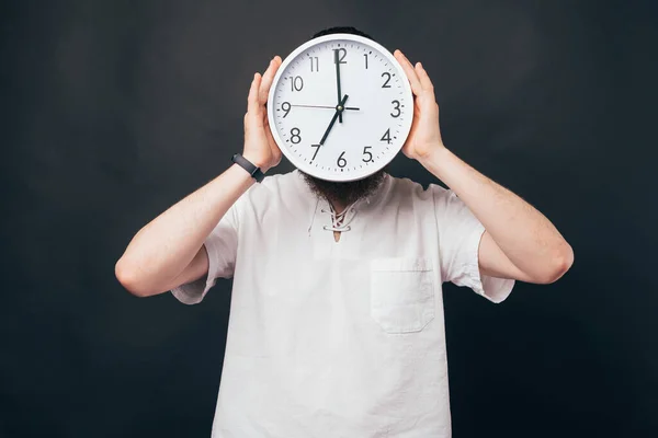 Foto Joven Sosteniendo Reloj Grande Cubriendo Cara Sobre Fondo Oscuro — Foto de Stock