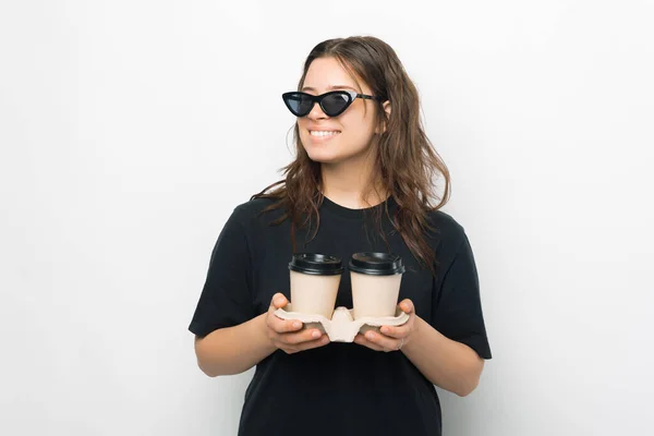 Молодая Модная Женщина Солнечных Очках Улыбается Держит Две Чашки Кофе — стоковое фото