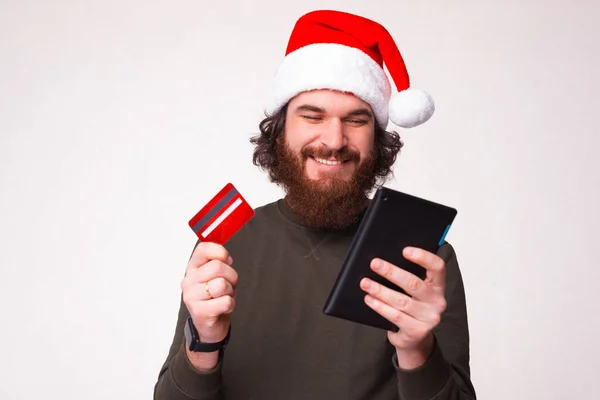 Portrait Cheerful Young Man Beard Wearing Santa Claus Hat Buying — Zdjęcie stockowe