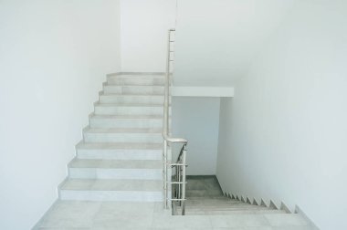 Beyaz merdivenli beyaz merdiven ve endüstriyel bir binanın duvarları.