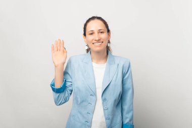 Mutluluk genç bayan, selam işareti gösteriyor. Beyaz arka planda stüdyo çekimleri.