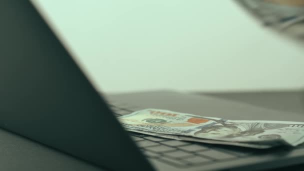 Закрыть кадры, на которых мужчина считает деньги возле ноутбука — стоковое видео
