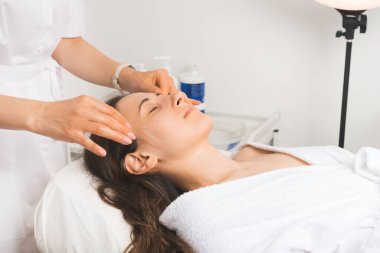 Yüz masajı haftanın en sevilen kısmı. Genç bir kadın kozmetikçide dinleniyor..