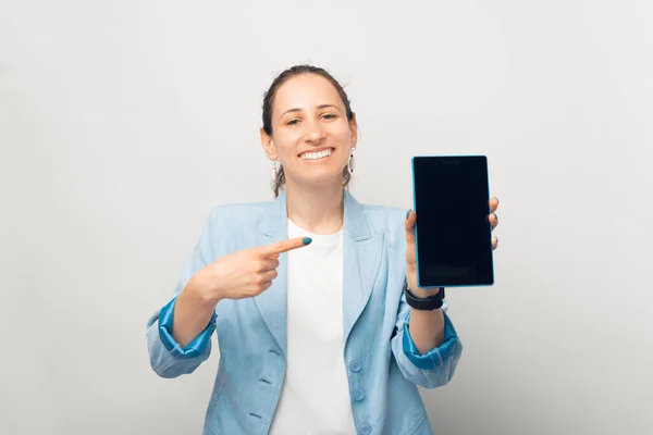 Gülümseyen Neşeli Kadın Beyaz Arka Planda Tabletin Ekranını Işaret Ediyor — Stok fotoğraf