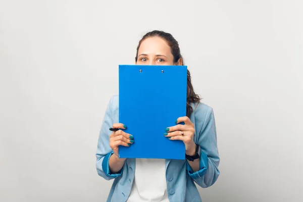 Překvapená Mladá Žena Skrývá Modrým Papírem — Stock fotografie
