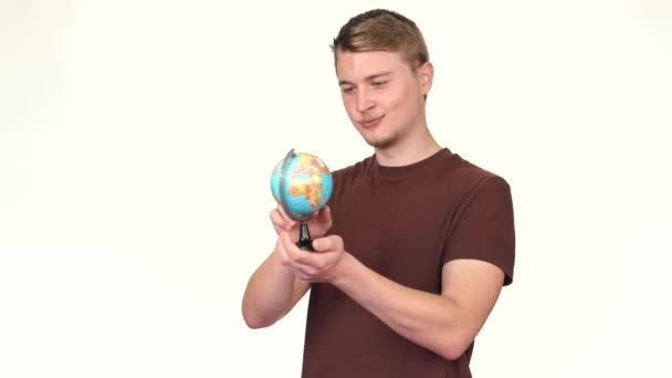 Кадри молодої людини, що вказують на глобус, концепція подорожей — стокове відео