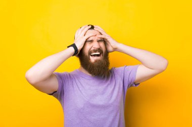 Elleri kafasında sakallı bir adam çığlık atıyor..