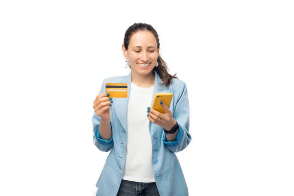 Genç iş kadını kredi kartını ve telefonunu cep telefonuyla tutuyor.. — Stok fotoğraf