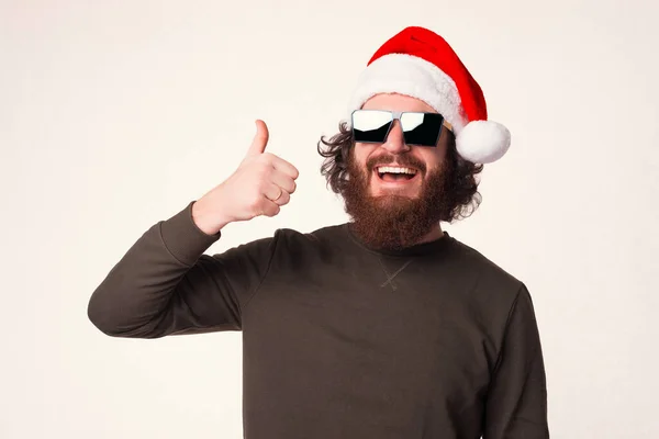 턱수염 남자가 크리스마스 때하얀 배경 위로 엄지손가락을 보여 주고 있습니다.. — 스톡 사진