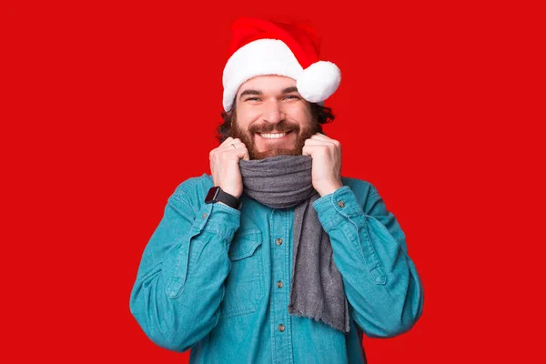 Προσωπογραφία του νεαρού χαρούμενου γενειοφόρου άνδρα φορώντας καπέλο santa claus πάνω από κόκκινο φόντο — Φωτογραφία Αρχείου