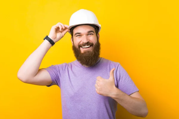 Védősapkát viselni jó ötlet - mondja a szakállas ember, akinek van egy, és felmutatja a hüvelykujját. — Stock Fotó