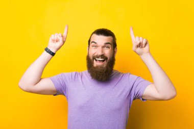 Teklif için heyecanlıyım. Sakallı adam sarı arka planı işaret ediyor..